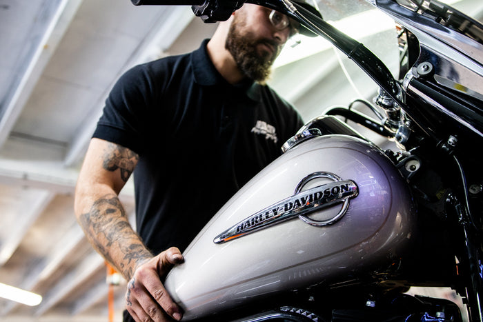 An Iron City technician working on a motorcycle in the workshop